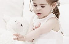 Niña pequeña jugando con un peluche.