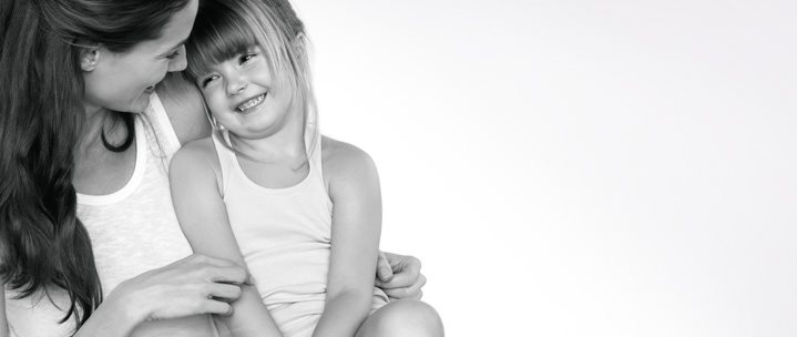 Madre con su hija abrazadas y sonriendo